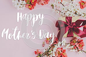 Happy mother`s day. Happy mothers day text and gift box with red and white flowers on pink background flat lay. Stylish floral