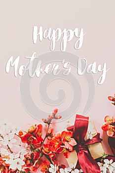 Happy mother`s day. Happy mothers day text and gift box with red and white flowers on pink background flat lay. Stylish floral