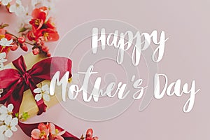 Happy mother`s day. Happy mothers day text and gift box with red and white flowers on pink background. Stylish floral greeting