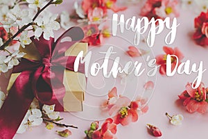 Happy mother`s day. Happy mothers day text and gift box with red and white flowers on pink background. Stylish floral greeting