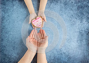 Happy mother`s day.Heart in the hands of daughter and mother on a blue background.I love you.Love and health in the family.Banner