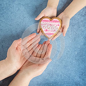 Happy mother`s day.Heart in the hands of my daughter and mother on a blue background.I love you.Love and health in the family.