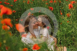 Happy Mother& x27;s Day. Little boy and mother is playing in a beautiful field of red poppies