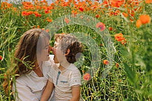 Happy Mother& x27;s Day. Little boy and mother is playing in a beautiful field of red poppies