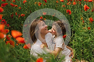 Happy Mother's Day. Little boy and mother is playing in a beautiful field of red poppies