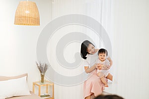 Happy mother`s day! Mom and her daughter child girl are playing, smiling and hugging