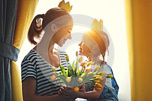 Happy mother`s day! mother and child daughter in crowns and with