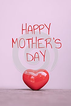 Happy Mother`s day text with red heart shaped ceramic for love concept