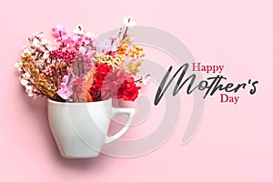 Happy Mother\'s Day. White cup of coffee with various flowers and the text Happy Mothers day