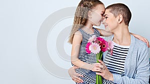 Happy Mother`s Day, Women`s day or Birthday background. Cute little girl giving mom bouquet of pink gerbera daisies. Loving mother