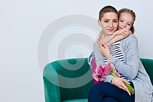 Happy Mother`s Day, Women`s day or Birthday background. Cute little girl giving mom bouquet of pink gerbera daisies. Loving mother