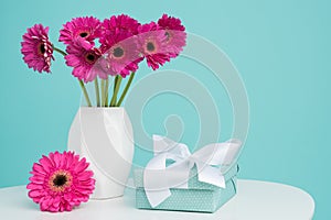 Dark pink gerberas in a vase on a retro table. Happy Mother`s Day, Women`s Day, Valentine`s Day or Birthday background. photo