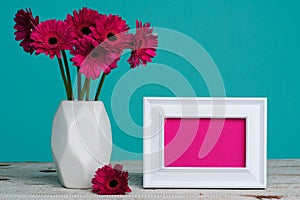 Happy Mother`s Day, Women`s Day, Valentine`s Day or Birthday Pastel Candy Blue Coloured Background. Dark pink gerberas in a vase. photo