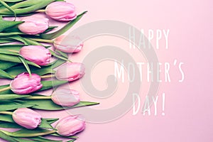 Happy Mother`s day wording with pink tulips on the pink background. Flat lay, top view. Mother`s day holiday celebration