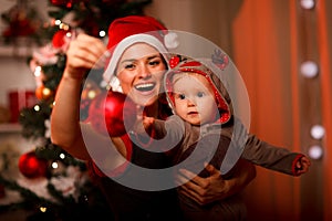 Contento madre visualizzato palla di natale sul un bambino 