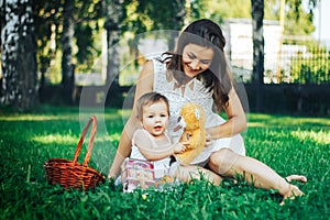 Happy mother sitting with her baby on grass