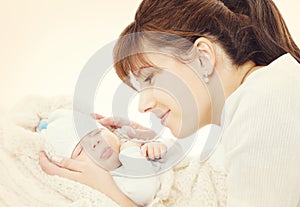 Happy Mother and Sleeping Newborn Baby, mom looking to New Born