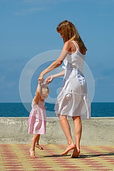 Happy mother and small girl dance