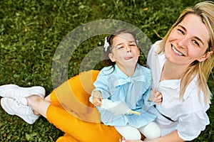 Happy mother smiling and playing with her child, enjoying the time together outdoors.