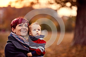 Happy mother with son at the autumn park enjoying together