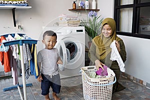 happy mother and son doing laundry together