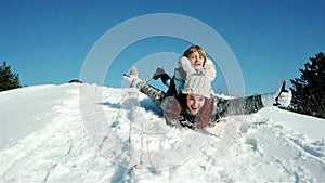 Happy mother and son moves down on sled, family sleigh ride through the snow, sledding down the hills, fast descent on