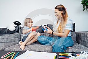 Happy mother and son playing role games with toys together in living room. Child psychotherapy process. Study in games