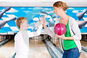 Mother and son playing together at bowling center