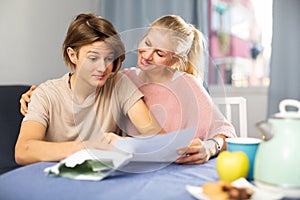 Happy mother and son reading letter from school