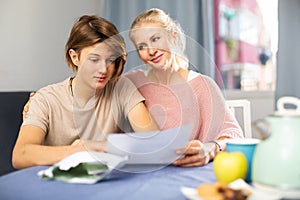 Happy mother and son reading letter from school