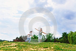 Happy Mother and son running on grass smiling