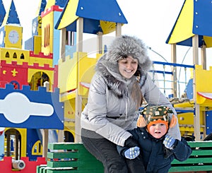 Happy mother and son in a winter playground