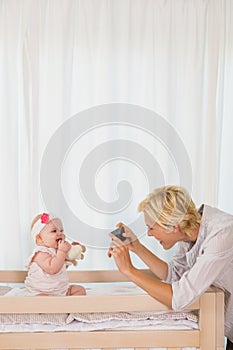 Happy mother taking a picture of her baby girl