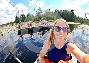 Happy Mother Taking Selfie with Family as they Boat and Fish on Pristine Lake on Summer Day