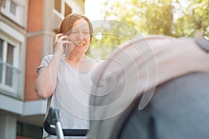 Happy mother talking on mobile phone