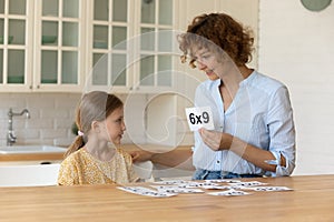 Happy mother teach small child daughter mathematics using flash cards