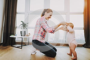 Happy Mother Teaching Baby Walking Indoors