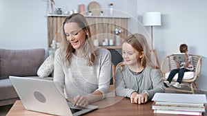 Happy mother teaching daughter working laptop pc remotely studying e learning distance education