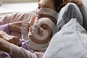 Happy mother and teen daughter relax at home dreaming