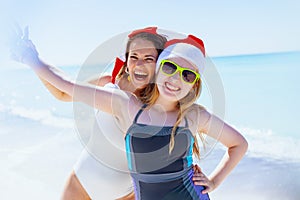 Happy mother and teenage daughter at beach having fun time