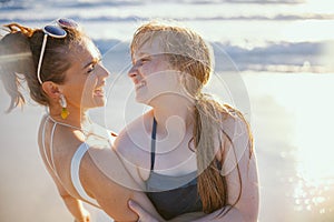 Happy mother and teenage daughter at beach having fun time