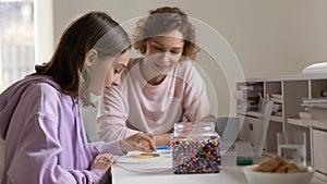 Happy mother and teenage daughter playing with colorful plastic mosaic