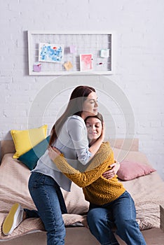 happy mother and teenage daughter smiling