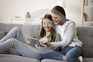 Happy mother and teenager girl using online application for shopping