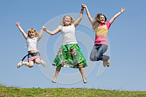 Happy Mother and two daughter jumping