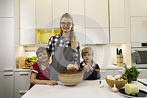 Happy mother and two kids preparing dough