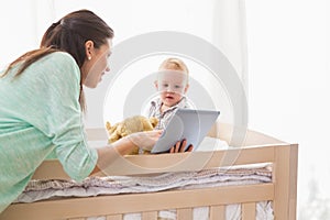 Happy mother using tablet with his baby boy