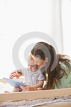 Happy mother using tablet with his baby boy