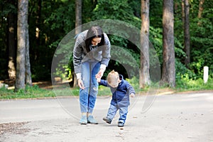Happy mother walking with her son in the park