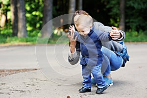 Happy mother walking with her son in the park